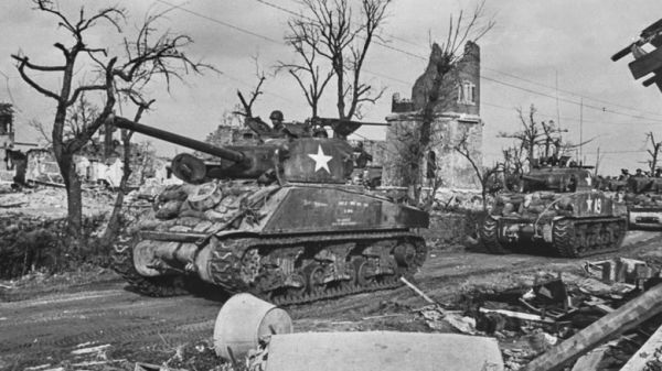 Soldiers inM4A3 Sherman tanks on dirt road