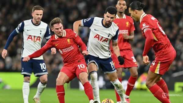 Gelandang Liverpool asal Argentina #10 Alexis Mac Allister (2K) bersaing dengan striker Inggris Tottenham Hotspur #19 Dominic Solanke (tengah) saat pertandingan sepak bola Liga Utama Inggris antara Tottenham Hotspur dan Liverpool di Stadion Tottenham Hotspur di London, pada 22 Desember 2024. (Photo by Glyn KIRK / AFP)
