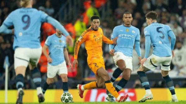 BELLINGHAM DIKEPUNG - Gelandang Real Madrid, Jude Bellingham dikepung pemain Manchester City pada pertandingan babak play-off 16 besar Liga Champions di Etihad Stadium, Rabu (12/2/2025) dini hari WIB. <div class=