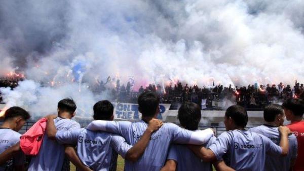 NYALAKAN FLARE - Bobotoh menyalakan flare saat memberikan dukungan kepada pemain Persib Bandung di Stadion Gelora Bandung Lautan Api, Kota Bandung, Kamis (13/2/2025). Dukungan diberikan menjelang Persib bertarung melawan Persija Jakarta, Minggu (16/2/2025).