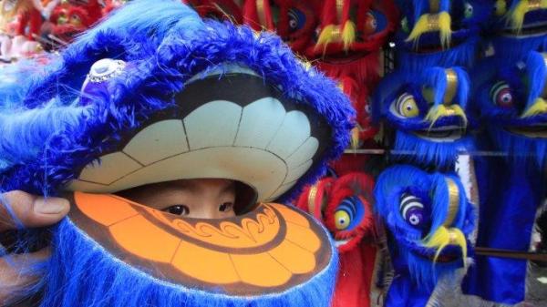 Seorang anak kecil mengenakan topeng barongsai dalam Kirab Budaya Perayaan Cap Go Meh 2576/2025 di Taman Kopo Indah, Kecamatan Margaasih, Kabupaten Bandung, Jawa Barat, Jumat (14/2/2025).