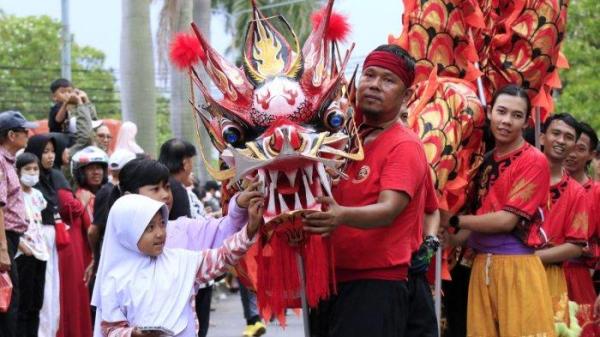Dua orang anak kecil memasukan angpao ke mulut liong dalam Kirab Budaya Perayaan Cap Go Meh 2576/2025 di Taman Kopo Indah, Kecamatan Margaasih, Kabupaten Bandung, Jawa Barat, Jumat (14/2/2025).