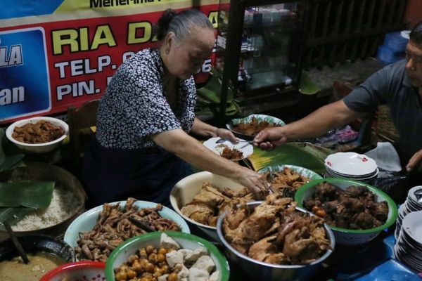 KULINER MALAM SOLO - Kasno (73) masih terampil mengkombinasikan berbagai macam lauk untuk hidangan Gudeg Cakar Mergoyudan andalan kedainya, Rabu (21/6/2017).