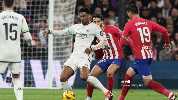Gelandang Real Madrid asal Inggris #5 Jude Bellingham (Kiri) berebut bola dengan bek Spanyol Atletico Madrid #22 Mario Hermoso dan penyerang Spanyol Atletico Madrid #19 Alvaro Morata selama pertandingan sepak bola liga Spanyol antara Real Madrid CF dan Club Atletico de Madrid di Stadion Santiago Bernabeu di Madrid pada 4 Februari 2024.