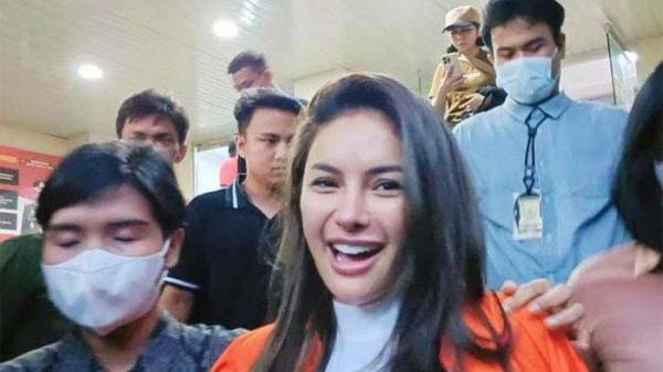 Nikita Mirzani tampak santai saat ditahan, ia berlenggak lenggok layaknya seorang model sambil menggerakkan tangannya.