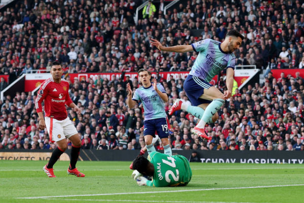 Penjaga gawang Manchester United Andre Onana berebut bola dengan pemain Arsenal Mikel Merino pada pertandingan Liga Inggris di Old Trafford, Manchester, Inggris, Minggu (9/3/2026).<div class=