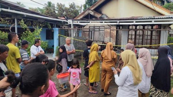 HANGUS - Sekelompok warga mendatangi rumah milik salah satu warga di Mahawu Manado yang terbakar.