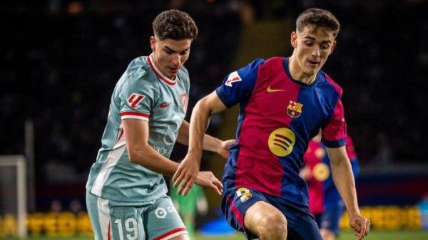 Pemain Barcelona Pedri berduel dengan pemain Atletico Madrid Julian Alvarez dalam pertandingan pekan ke-17 Laliga Spanyol 2024/2025.