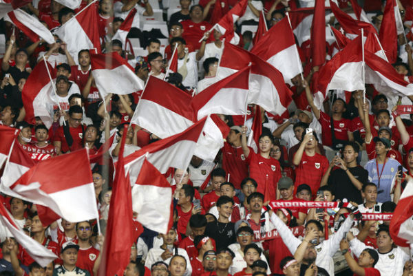 Pendukung Timnas Indonesia menyanyikan yel-yel dan mengibarkan bendera merah putih pada pertandingan Kualifikasi Piala Dunia 2026 di Stadion Utama Gelora Bung Karno, Jakarta, Selasa (25/3/2025).  Foto: Ajeng Dinar Ulfiana/Reuters