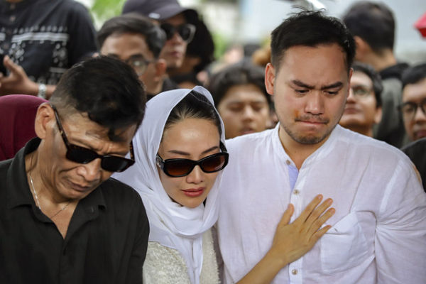 Anak dari aktor Ray Sahetapy, Rama Sahetapy (kanan) bersama istri Merdi Octav (tengah) menangis saat pemakaman aktor Ray Sahetapy di TPU Tanah Kusir, Jakarta, Jumat (4/4/2025). Foto: Jamal Ramadhan/kumparan