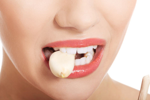 Ilustrasi orang makan bawang putih. Foto: Shutterstock