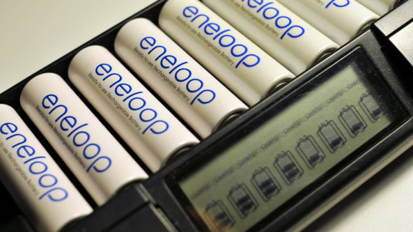 eneloop batteries in an eneloop chargere. The batteries are white with blue writing and say 