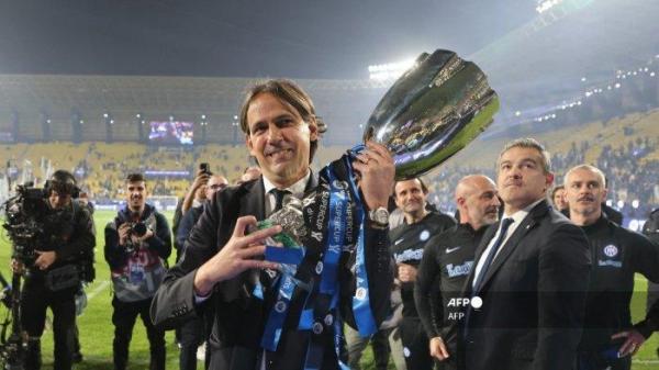 Pelatih Inter Milan asal Italia Simone Inzaghi membawa trofi usai memenangi pertandingan sepak bola final Piala Super Italia antara Napoli dan Inter Milan di Stadion Al-Awwal Park di Riyadh, pada 22 Januari 2024. AFP