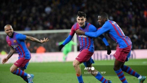 Gelandang Barcelona Spanyol Pedri merayakan mencetak gol pembuka dengan pemain depan Barcelona Prancis Ousmane Dembele (kanan) dan bek Barcelona Brasil Dani Alves (kiri) selama pertandingan sepak bola Liga Spanyol antara FC Barcelona dan Sevilla FC di stadion Camp Nou di Barcelona pada 3 April, 2022. Juara Liga Inggris Manchester City berencana untuk 'mendobrak pasar' dengan tawaran yang memecahkan rekor Inggris untuk bintang Barcelona Pedri 
LLUIS GEN / AFP