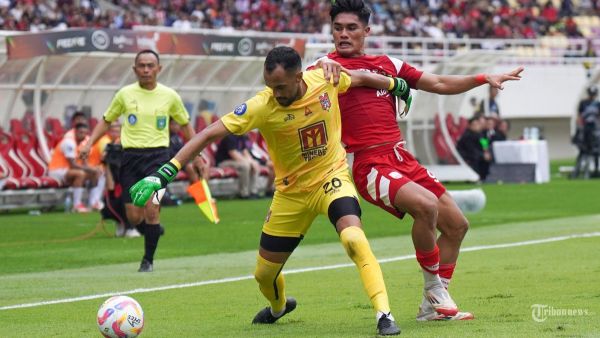 BEREBUT BOLA - Pesepak bola Persis Solo, Ramadhan Sananta (kanan) berebut bola dengan penjaga gawang Malut United, Wagner Augusto Guimares dalam pertandingan Liga 1 di Stadion Manahan, Solo, Sabtu(12/4/2025) sore. Malut United menang 3-1 atas Persis Solo berkat hattrick Yakob Sayuri. Tribun Solo/Muhammad Nursina