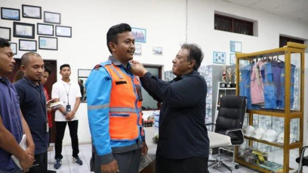 Direktur LHC PLN Yusuf Didi Setiarto saat menyematkan PIN PLN kepada Petugas Pelayanan