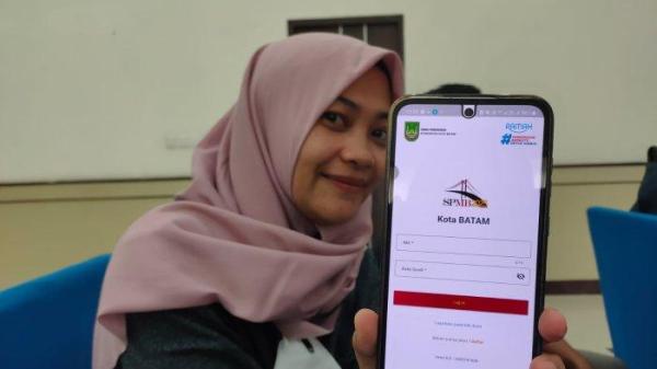 Seorang wanita menunjukkan aplikasi SPMB Kota Batam untuk pendaftaran sekolah, Kamis (22/5/2025)