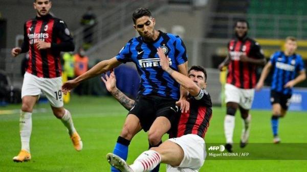 Bek Inter Milan asal Maroko Achraf Hakimi (kiri) bertarung memperebutkan bola dengan bek Italia AC Milan Alessio Romagnoli dalam pertandingan sepak bola Serie A Italia antara Inter Milan dan AC Milan di stadion San Siro di Milan pada 17 Oktober 2020.