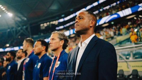 PATRICK KLUIVERT DI BENCH PEMAIN.- Di foto pertama Patrick Kluivert sedang berada di bench skuat Timnas Indonesia di Sydney Football Stadium pada Kamis (20/3/2025). Patrick Kluivert terlihat memakai jas berwarna hitam. Patrick Kluivert berdiri di samping Alex Pastoor, asisten pelatih Timnas Indonesia.  Di foto itu juga terlihat sejumlah staff pelatih Timnas Indonesia