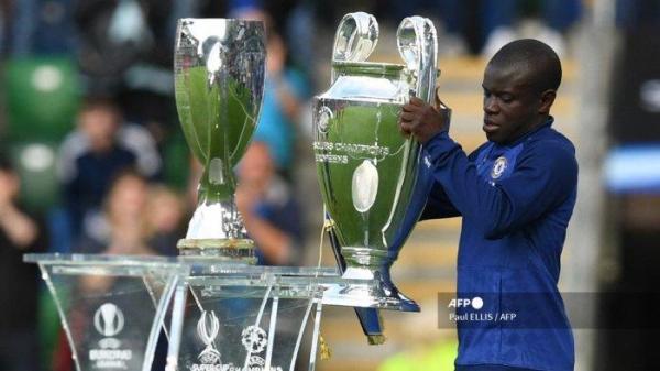 Gelandang Chelsea asal Prancis N'Golo Kante meletakkan trofi Liga Champions di stand di sebelah trofi Piala Super menjelang pertandingan sepak bola Piala Super UEFA antara Chelsea dan Villarreal di Windsor Park di Belfast pada 11 Agustus 2021.
