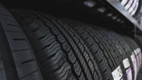 A lineup of passenger car tires sitting on a shelf