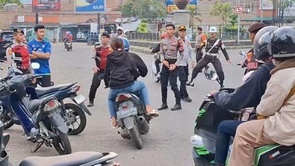 KABUR - Pengendara menerobos petugas yang melakukan razia di Jalan Raya Katapang-Soreang, Kecamatan Katapang, Kabupaten Bandung, Jumat (30/5/2025).