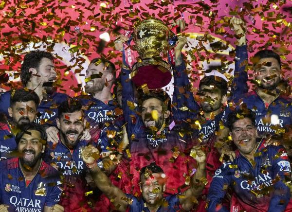 Royal Challengers Bengaluru’s captain Rajat Patidar, Virat Kohli and others celebrate with the championship trophy.