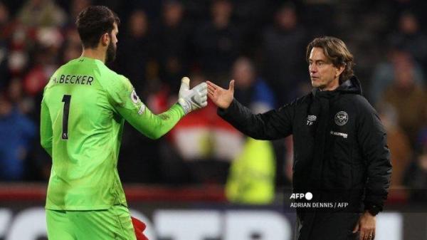 Pelatih kepala Brentford Thomas Frank (Kanan) berjabat tangan dengan kiper Liverpool Alisson Becker (Kiri) di lapangan setelah pertandingan sepak bola Liga Utama Inggris antara Brentford dan Liverpool di Gtech Community Stadium di London pada 2 Januari 2023. Brentford memenangkan pertandingan 3-1.