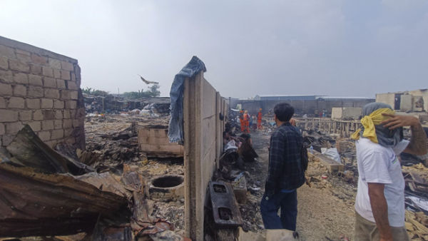 Sejumlah warga berada di antara puing-puing rumah yang hangus dalam kebakaran permukiman padat penduduk di Jalan Kapuk Raya, Kapuk Muara, Penjaringan, Jakarta, Sabtu (7/6/2025). Foto: Thomas Bosco/kumparan