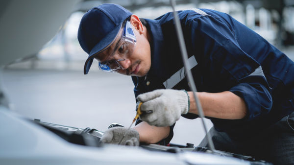 A mechanic working on a car engine