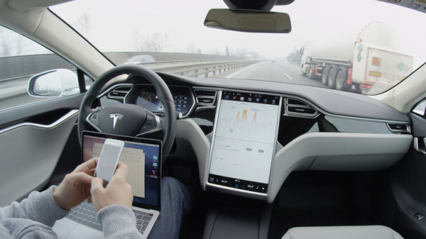 Driver using the autopilot feature in a Tesla Model S