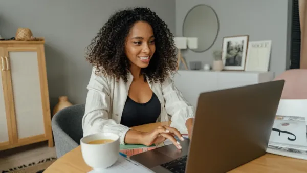 user using laptop having coffee