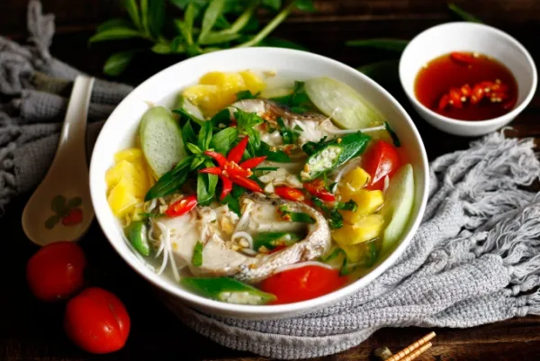 A bowl of canh chua ca bursts with vibrant colors from pineapple, tomatoes, and okra. Photo by Read/Bui Thuy
