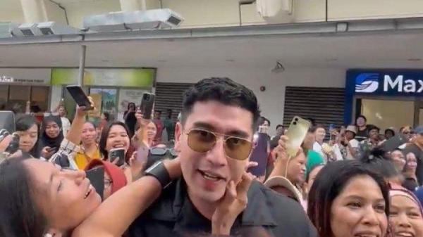 DIKERUMUNI FANS - Verrell Bramasta dikerumuni penggemar, sebagian besar perempuan saat tengah liburan di Singapura, Minggu (8/6/2025). Dalam insiden ini Verrell Bramasta dibantu pihak kepolisian Singapura. (Instagram/Verrell Bramasta).