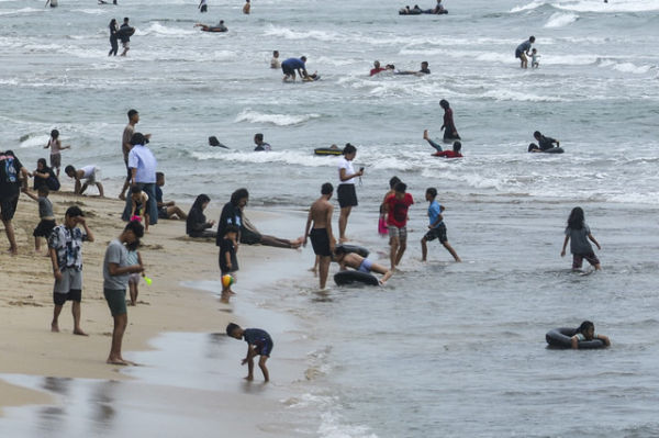 Sejumlah wisatawan bermain air di Pantai Anyer, Kabupaten Serang, Banten, Selasa (1/4/2025). Foto: Muhammad Bagus Khoirunas/ANTARA FOTO