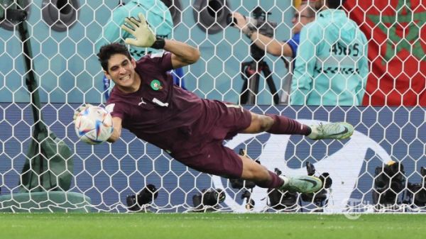 Kiper Maroko Yassine Bounou membelokkan tendangan penalti dari gelandang Spanyol  Sergio Busquets yang membawa kemanangan Timnas Maroko saat duel adu penalti di pertandingan sepak bola babak 16 besar Piala Dunia Qatar 2022 antara Maroko dan Spanyol di Stadion Education City di Al-Rayyan, barat Doha. Selasa (6 Desember 2022). (JACK GUEZ/AFP)