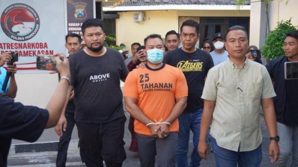 TAMPAK GAGAH: Wajah tersangka Zainal Arifin yang cekik kurir JNT lantaran paketan Hp yang dipesan istrinya tak sesuai gambar saat digiring masuk ke ruang tahanan Polres Pamekasan, Madura, Rabu (2/7/2025)