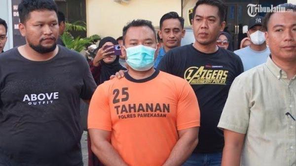 DIAMANKAN - Wajah tersangka Zainal Arifin yang cekik kurir JNT lantaran paketan Hp yang dipesan istrinya tak sesuai gambar saat digiring masuk ke ruang tahanan Polres Pamekasan, Madura, Rabu (2/7/2025).