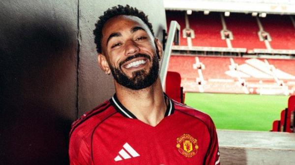 PEMAIN BARU MU - Pemain baru Manchester United, Matheus Cunha tersenyum saat sesi foto di Old Trafford.