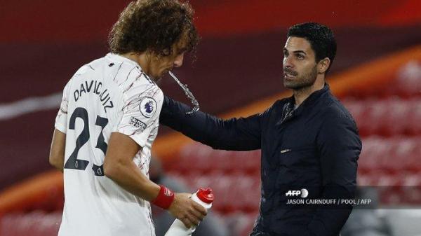 Bek Arsenal asal Brazil David Luiz (kiri) meludahi air saat ia berbicara dengan manajer Arsenal Spanyol Mikel Arteta selama pertandingan sepak bola Liga Utama Inggris antara Liverpool dan Arsenal di Anfield di Liverpool, Inggris barat laut pada 28 September 2020.JASON CAIRNDUFF / POOL / AFP