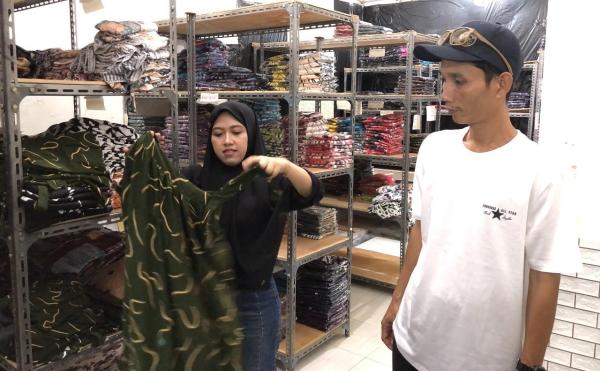 Harisa dan Yanto saat menunjukkan salah satu produk dasternya saat ditemui pada Jumat 24 Juli 2025. Kisah Sukses Suami Istri Jual Daster Bali, Raih Omzet Hingga Ratusan Juta, Bagi Tips Jualan Online