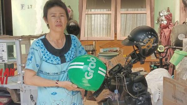 AKUN DISUSPEND APLIKATOR - Rosdewi (40) sedang berdiri di samping sepeda motor miliknya dan kardus hasilnya memulung, Selasa (22/7/2025).