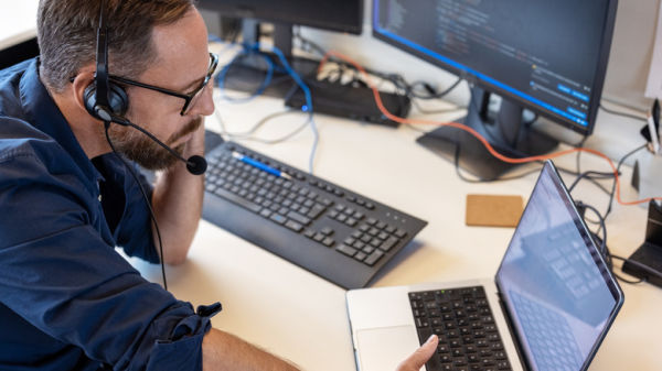 man wearing headphones near a laptop