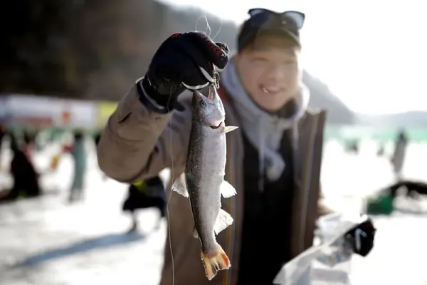 A boy reacts after catching a trout with his hands during an event promoting the Ice Festival in Hwacheon, south of the demilitarized zone (DMZ) separating the two Koreas, South Korea January 6, 2018. REUTERS/Kim Hong-Ji