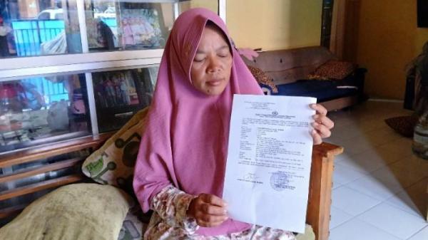 Chaeriyah (49) menunjukkan surat laporan yang disampaikan ke Polres Tegal Kota atas dugaan penganiayaan Pandu terhadap anaknya Rizki.