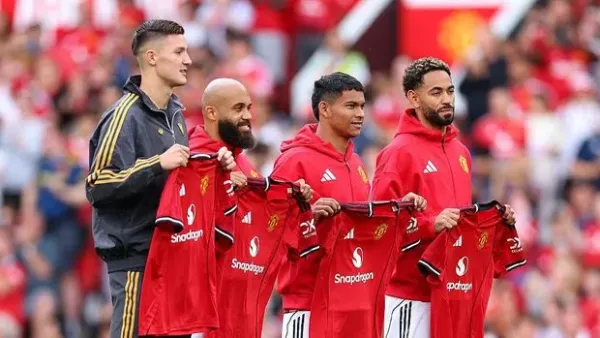 MANCHESTER, ENGLAND - AUGUST 09: New signings Bryan Mbeumo, Benjamin Sesko, Diego Leon and Matheus Cunha of Manchester United pose for a photo while holding match shirts prior to the pre-season friendly match between Manchester United and ACF Fiorentina at Old Trafford on August 09, 2025 in Manchester, England. (Photo by Molly Darlington/Getty Images)
