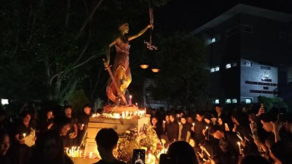AKSI SOLIDARITAS - Ratusan mahasiswa memberikan penghormatan terakhir melalui penyalaan lilin dan prosesi tabur bunga kepada mendiang mahasiswa FH Unnes, Iko Juliant Junior. Acara berlangsung di Patung Dewi Themis, Fakultas Hukum Unnes, Kampus Sekaran, Kecamatan Gunungpati, Kota Semarang, Selasa (2/9/2025) malam.