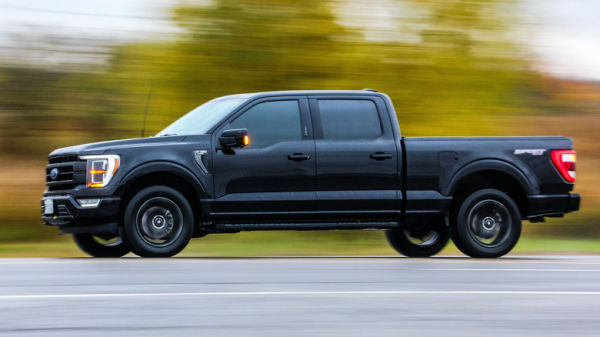 A black Ford F150 on a road against blur background