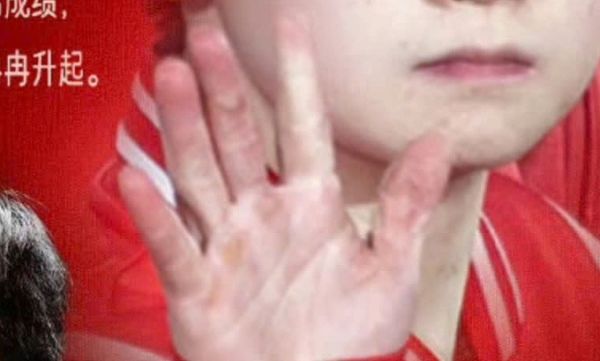 A screenshot of Sun Yingshas hand on the poster of Peoples Daily