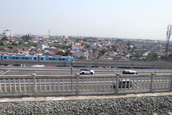 Kereta LRT Jabodebek dan jalan tol MBZ dilihat dari jendela Kereta Cepat Whoosh, Senin (4/8/2025). Foto: M. Rizki/kumparan